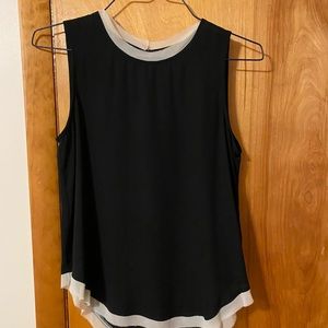Small Black blouse, sleeveless with a white collar.